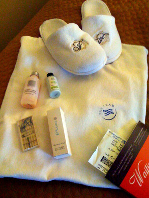 a white slippers and a white towel with a few items on it