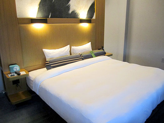 a bed with a white sheet and pillows